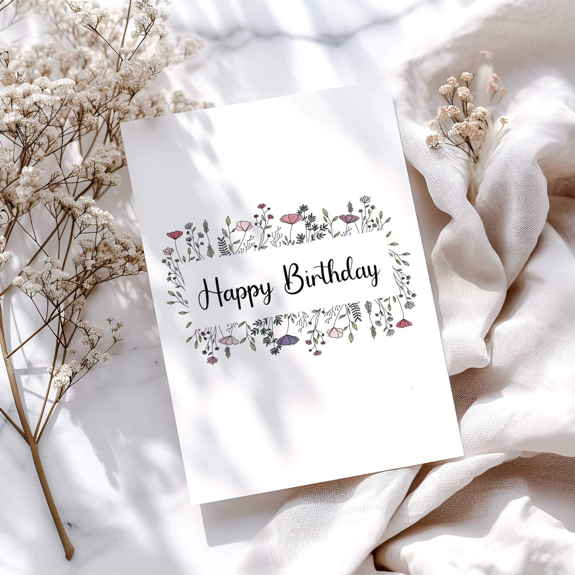 Elegant floral birthday card design featuring hand-drawn wildflowers in pink and purple. Modern calligraphy 'Happy Birthday' text surrounded by delicate botanical illustrations