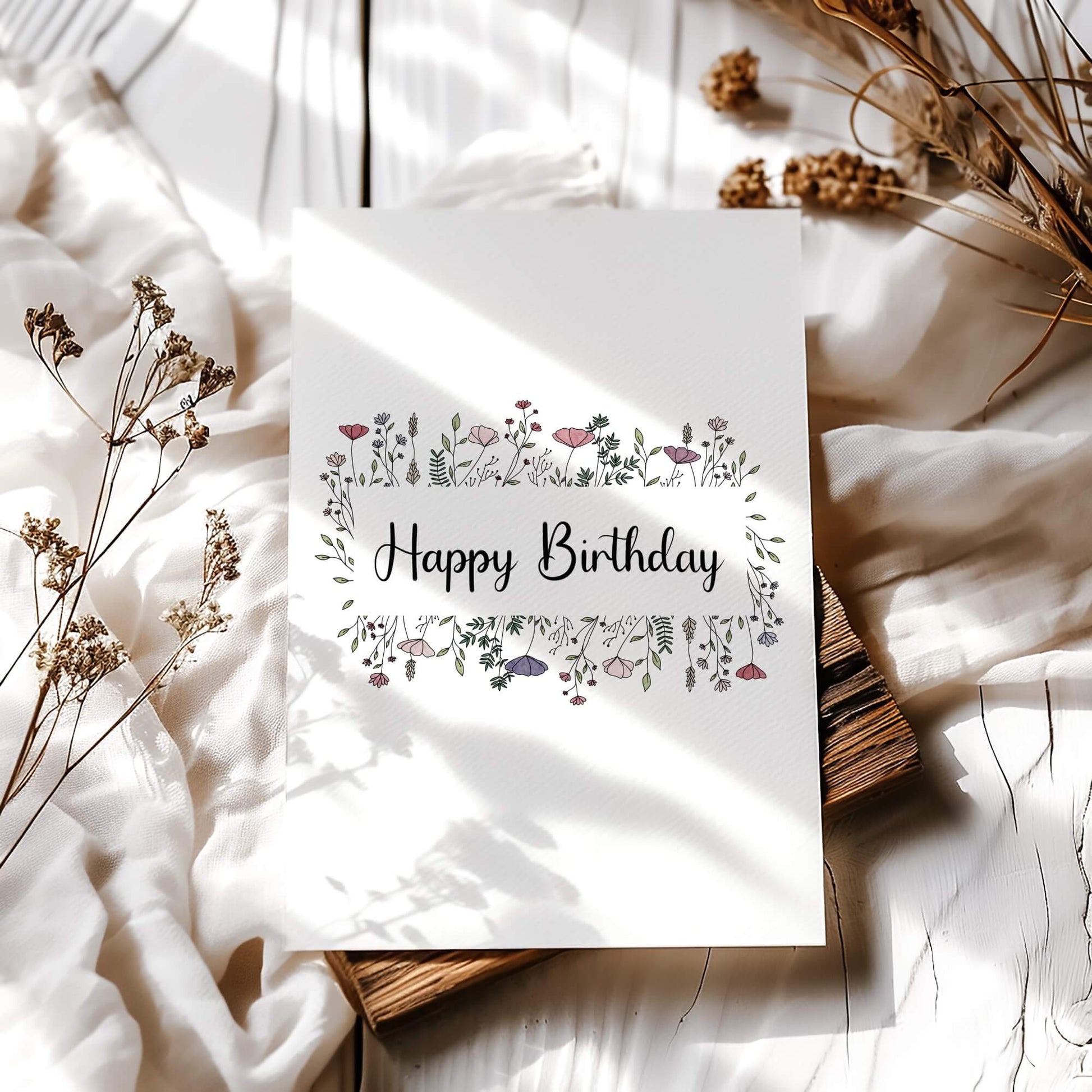 Botanical birthday card with pink and purple wildflower frame styled with vintage books and dried flowers. Minimalist printable greeting card with natural sunlight shadows and rustic elements
